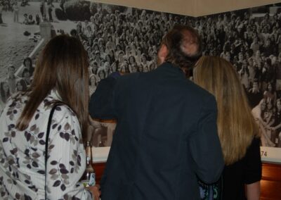 Beverly Hills High School class of 1974 40th reunion party. 3 people looking at the class photo.