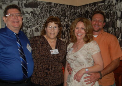 40th reunion at Maggiano's, pictured are Marie Page Knecht, Marie's husband Jeffrey Knecht, Pandora Victor, and ???who??? standing in front of the original Class of 74 photo.