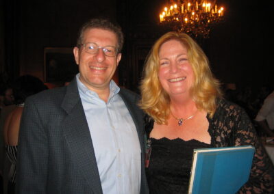 30th reunion Mayer Brenner and Julie Lifson smiling at camera. Julie Lifson is holding our senior year Yearbook.